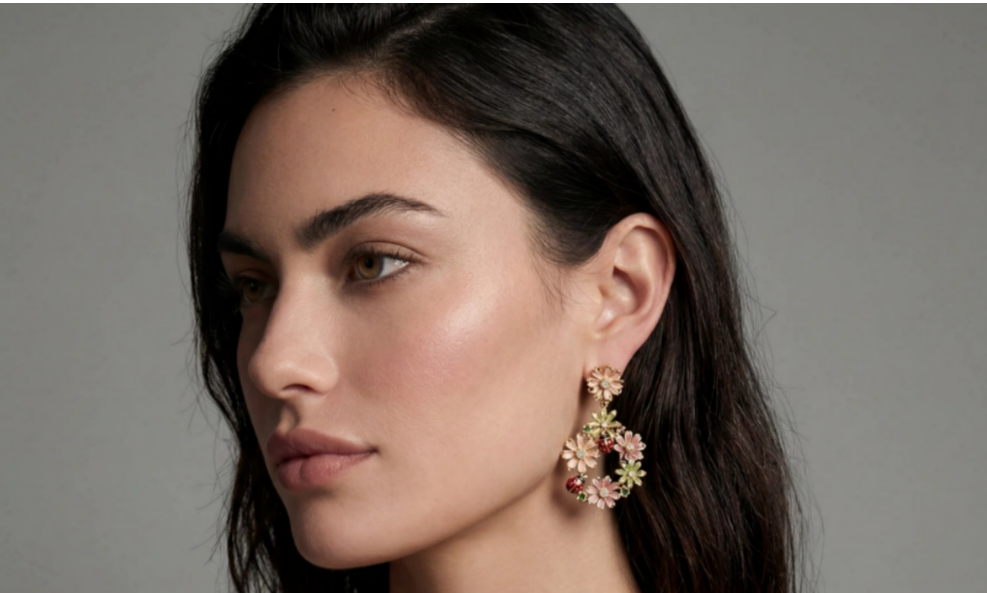 Woman wearing gold jewelry with floral designs on a gray background